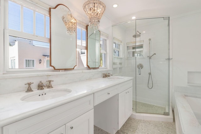 bathroom with double vanity, a stall shower, and a sink