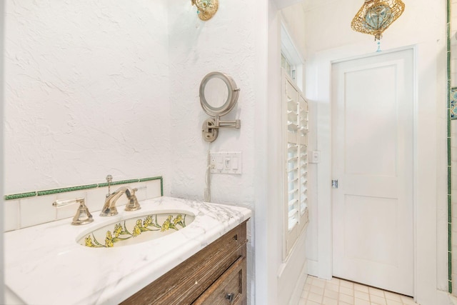 bathroom with vanity and a textured wall