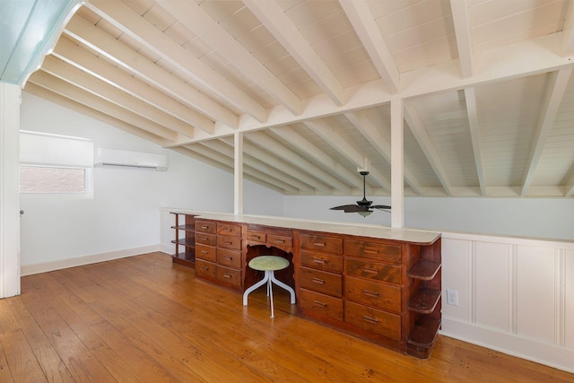 office area featuring a ceiling fan, lofted ceiling with beams, an AC wall unit, hardwood / wood-style flooring, and wooden ceiling