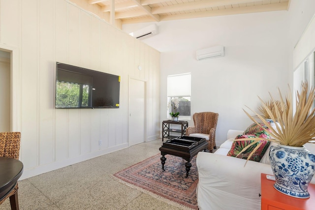 interior space with speckled floor, beam ceiling, and a wall mounted AC