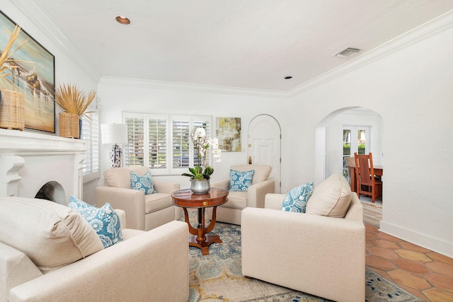 tiled living area with arched walkways, visible vents, crown molding, and baseboards