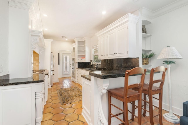 kitchen with open shelves, a sink, tasteful backsplash, white cabinetry, and appliances with stainless steel finishes