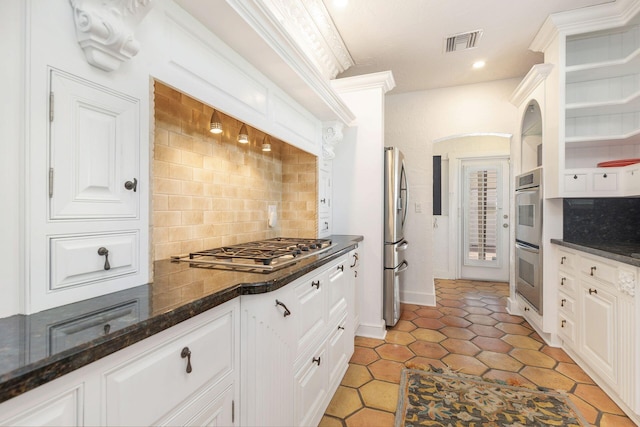 kitchen with visible vents, backsplash, dark stone countertops, stainless steel appliances, and white cabinetry