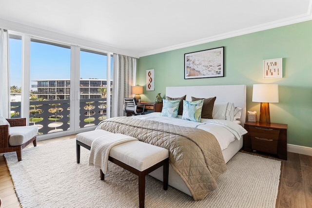 bedroom with a wall of windows, crown molding, wood finished floors, and baseboards