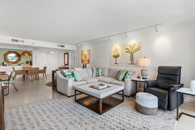 living area with crown molding, visible vents, tile patterned floors, and track lighting