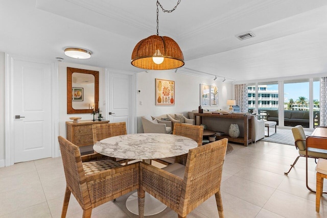 dining room featuring rail lighting, light tile patterned floors, visible vents, and ornamental molding