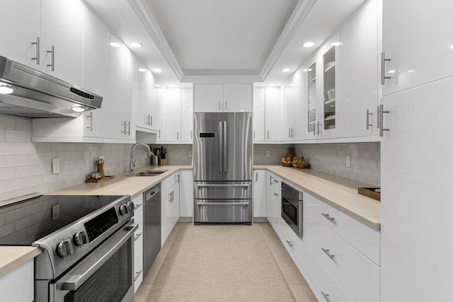 kitchen with stainless steel appliances, decorative backsplash, white cabinets, glass insert cabinets, and under cabinet range hood