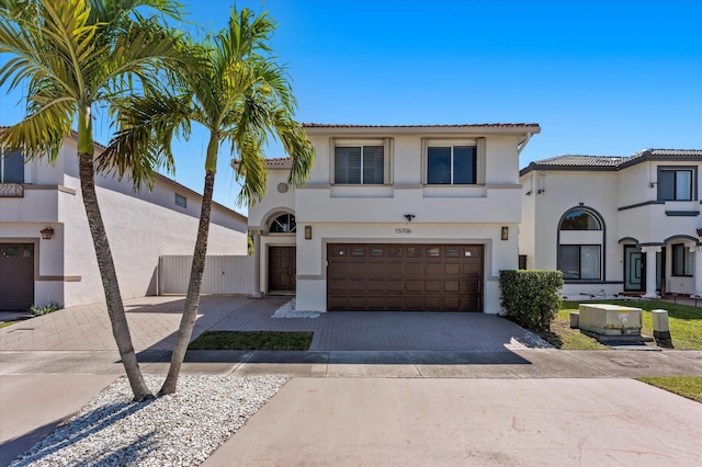 mediterranean / spanish house featuring a tiled roof, stucco siding, and driveway