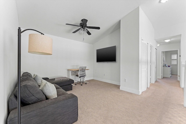 living room with a ceiling fan, lofted ceiling, light colored carpet, and baseboards