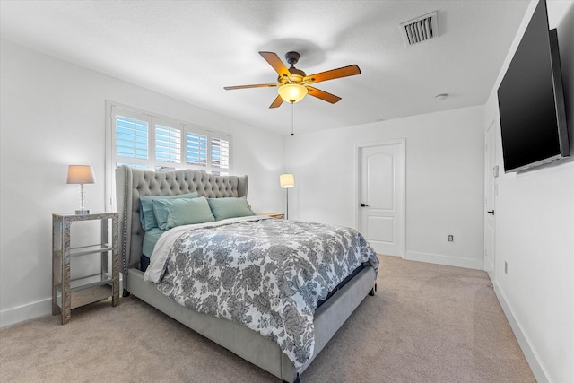 bedroom with visible vents, light carpet, baseboards, and a ceiling fan