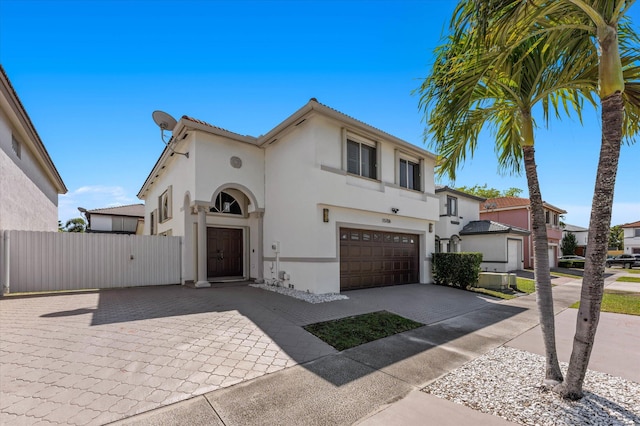 view of front facade featuring a gate, fence, a garage, and stucco siding