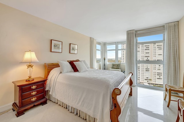 bedroom featuring access to outside, light tile patterned floors, and baseboards