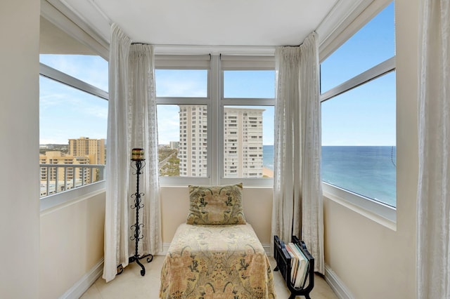 sitting room with baseboards, a water view, and tile patterned flooring