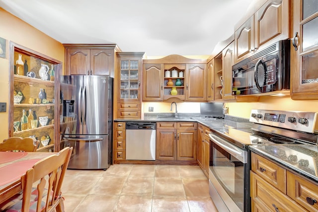 kitchen with open shelves, a sink, stainless steel appliances, brown cabinetry, and light tile patterned floors