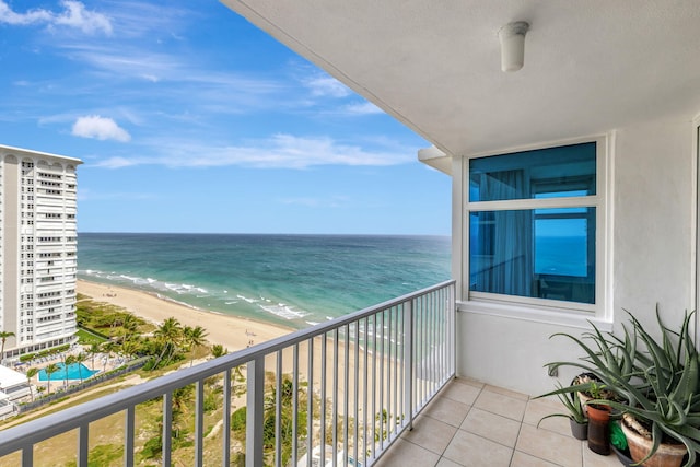 balcony with a water view and a view of the beach