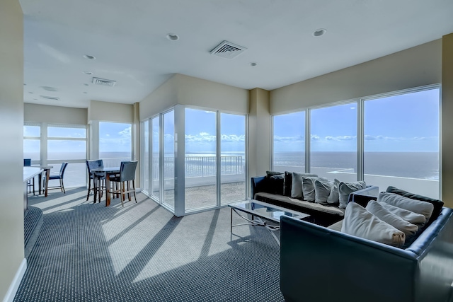 carpeted living room with visible vents and a water view