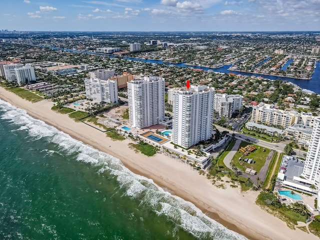 drone / aerial view with a water view, a city view, and a beach view