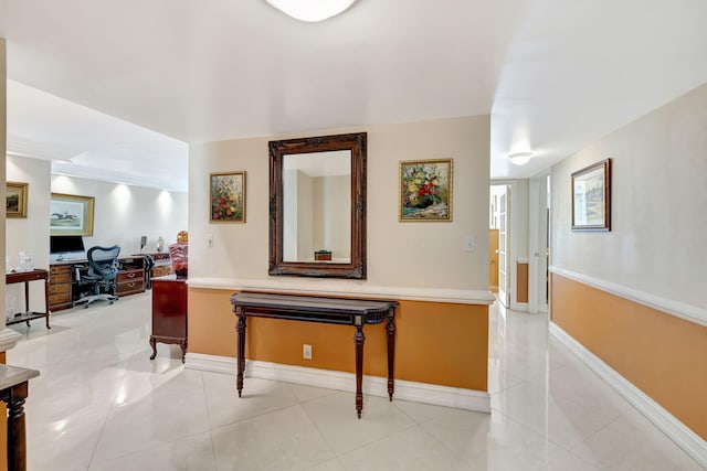 hall with light tile patterned flooring and baseboards