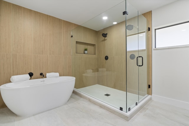 bathroom featuring a freestanding bath and a shower stall