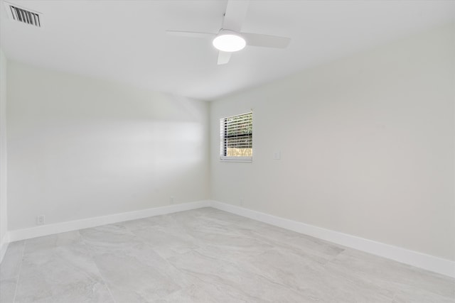 empty room featuring baseboards, visible vents, and ceiling fan