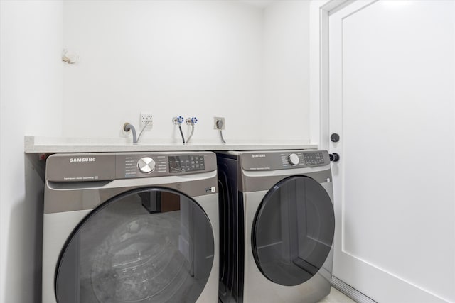 clothes washing area featuring washer and clothes dryer and laundry area