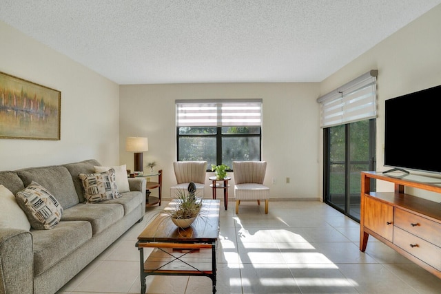 living room featuring light tile patterned floors, a textured ceiling, and baseboards