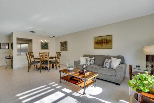 living area with an inviting chandelier, light tile patterned flooring, baseboards, and visible vents