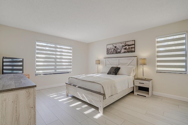 bedroom with light wood-style floors and baseboards