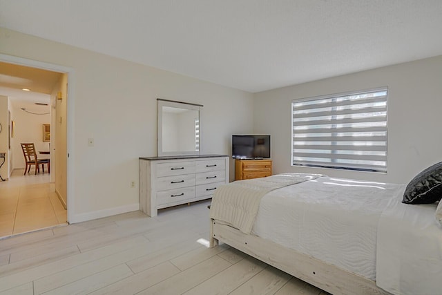 bedroom featuring baseboards and light wood finished floors