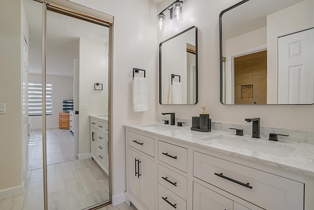 full bathroom with a sink, connected bathroom, and double vanity