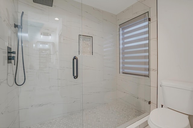 full bathroom with a marble finish shower and toilet