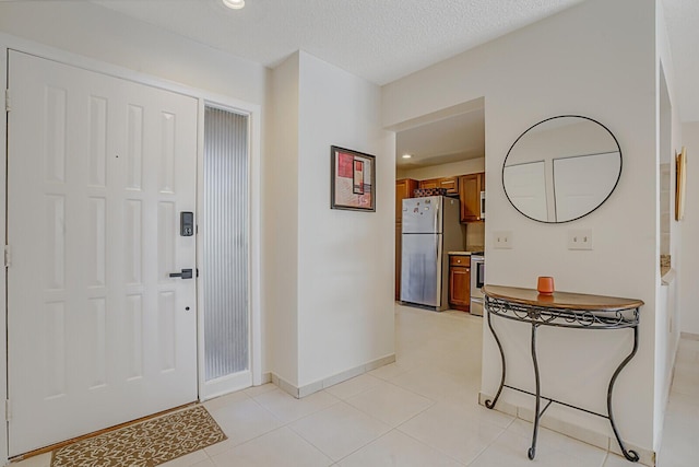 entryway featuring light tile patterned floors, recessed lighting, a textured ceiling, and baseboards