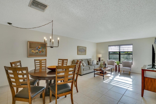 dining area featuring visible vents, a notable chandelier, light tile patterned flooring, and a textured ceiling