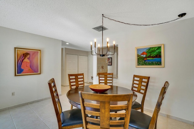 dining area featuring visible vents, baseboards, a textured ceiling, and light tile patterned flooring