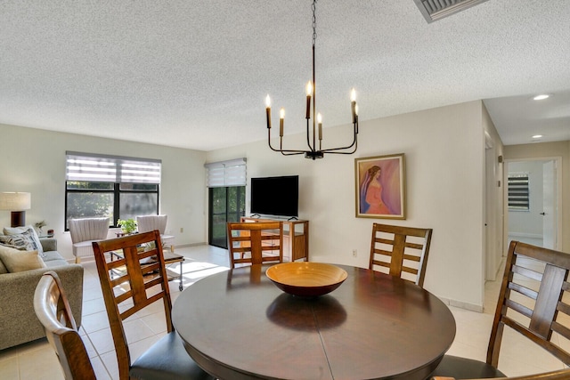 dining space with light tile patterned flooring, visible vents, a textured ceiling, and baseboards