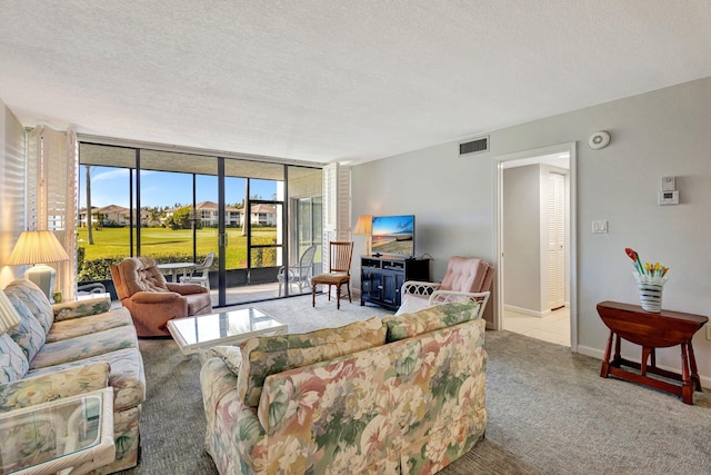 living room with visible vents, baseboards, expansive windows, carpet floors, and a textured ceiling