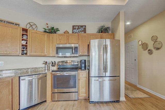 8290 Mulligan Cir Unit 2421, Port Saint Lucie, FL 34986 - kitchen featuring appliances with stainless steel finishes, light wood-style floors, light stone counters, baseboards, and recessed lighting