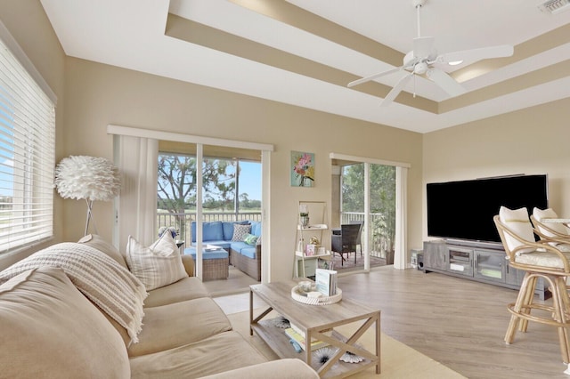 8290 Mulligan Cir Unit 2421, Port Saint Lucie, FL 34986 - living area featuring plenty of natural light, light wood finished floors, ceiling fan, and a raised ceiling