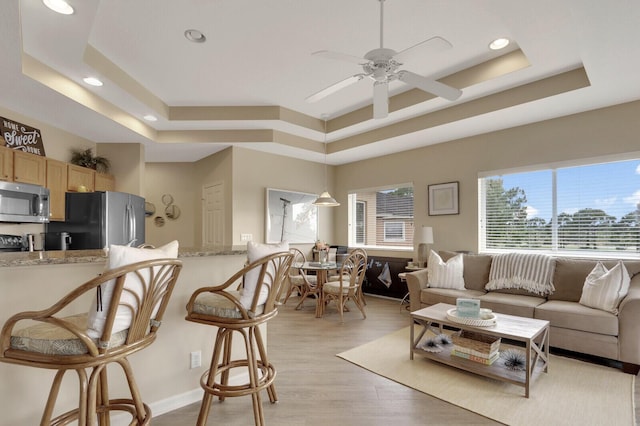 8290 Mulligan Cir Unit 2421, Port Saint Lucie, FL 34986 - living area featuring a tray ceiling, recessed lighting, light wood finished floors, and a ceiling fan
