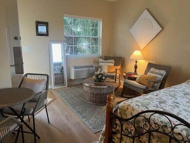 8290 Mulligan Cir Unit 2421, Port Saint Lucie, FL 34986 - bedroom with wood finished floors and a wall unit AC