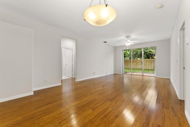 spare room featuring hardwood / wood-style floors, baseboards, and ceiling fan