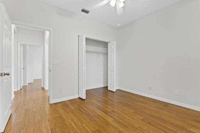 unfurnished bedroom featuring light wood-type flooring, visible vents, a closet, baseboards, and ceiling fan