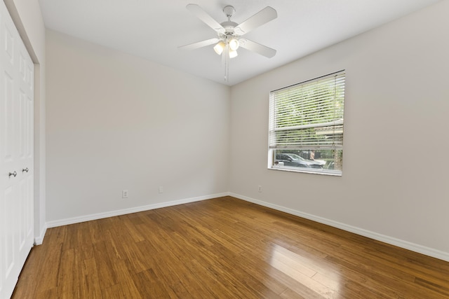 empty room with ceiling fan, baseboards, and wood finished floors