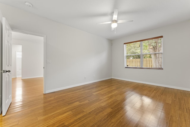 unfurnished room with baseboards, a ceiling fan, and light wood finished floors