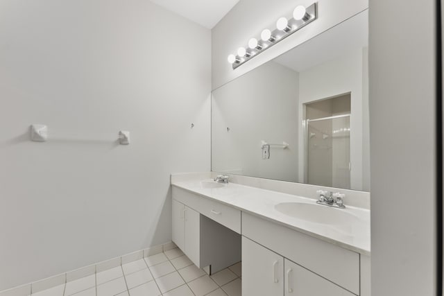 full bath featuring a sink, double vanity, a stall shower, and tile patterned floors