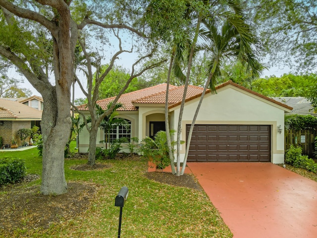 view of front of house with stucco siding, an attached garage, a tile roof, and concrete driveway