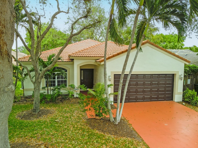 mediterranean / spanish house with stucco siding, a tiled roof, concrete driveway, and a garage