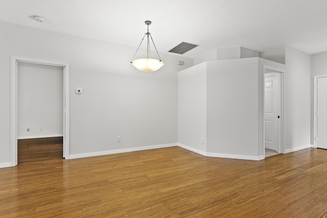 unfurnished room featuring visible vents, baseboards, and light wood-style floors