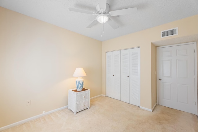 unfurnished bedroom with carpet flooring, visible vents, a closet, and a textured ceiling