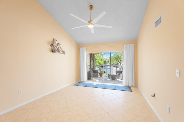 unfurnished room with visible vents, lofted ceiling, light tile patterned flooring, a textured ceiling, and a ceiling fan